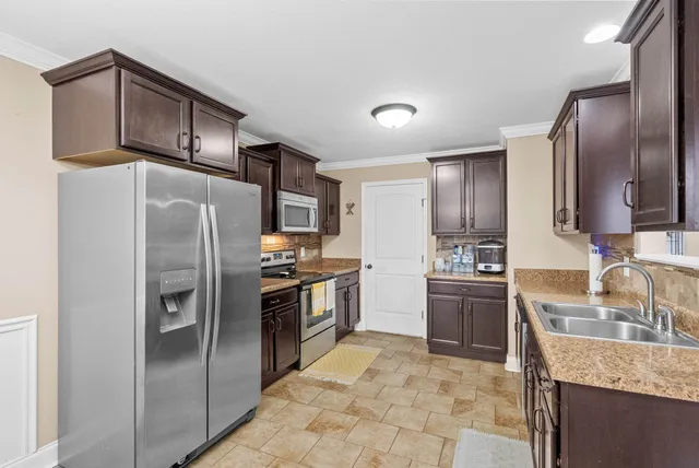 a kitchen with stainless steel appliances granite countertop a refrigerator sink and stove