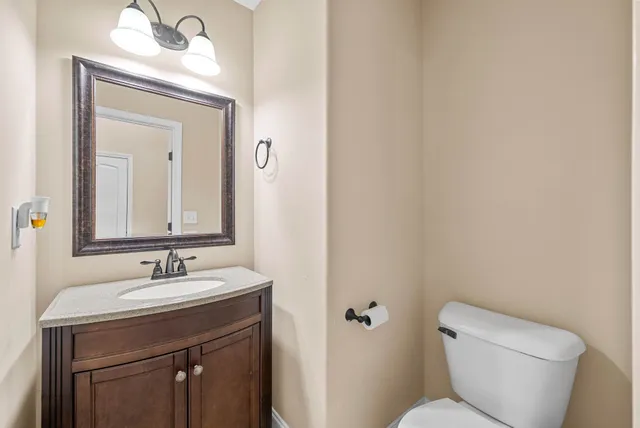 a bathroom with a toilet a sink and mirror