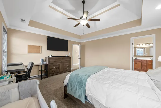 a spacious bedroom with a bed and a flat screen tv