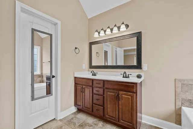 a bathroom with a double vanity sink and mirror