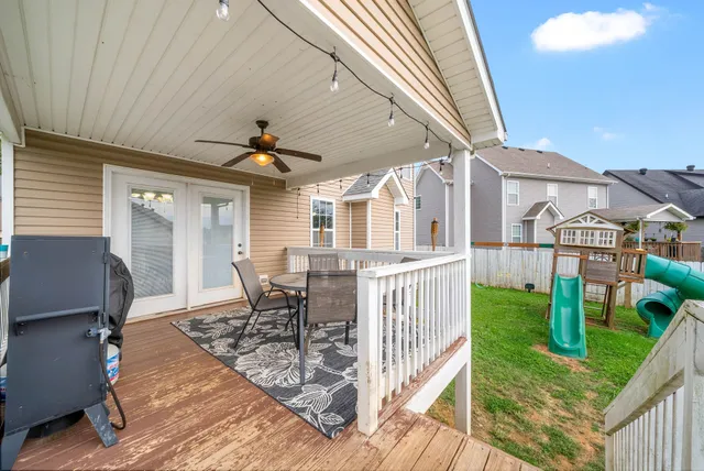 a view of a patio with table and chairs with wooden floor and fence