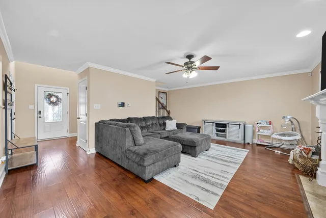 a living room with furniture and a wooden floor