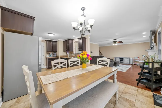 a view of a dining room and livingroom with furniture wooden floor a chandelier