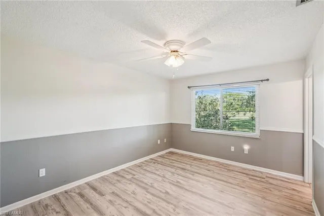 a view of an empty room with a window and a ceiling fan