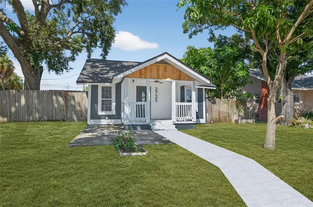 a front view of a house with a yard and trees