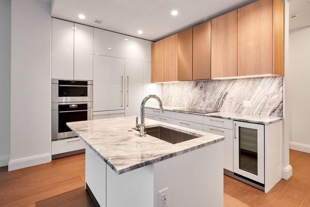 a kitchen with stainless steel appliances granite countertop a sink and a refrigerator