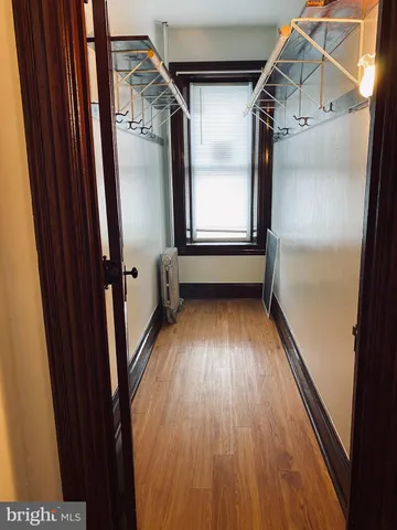 a view of walk in closet with wooden floor and windows