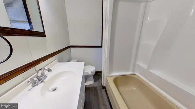 a bathroom with a tub sink and mirror