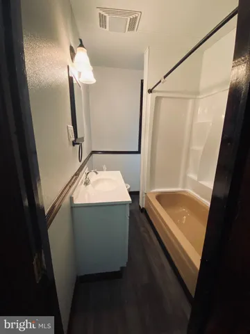 a bathroom with a tub sink and mirror