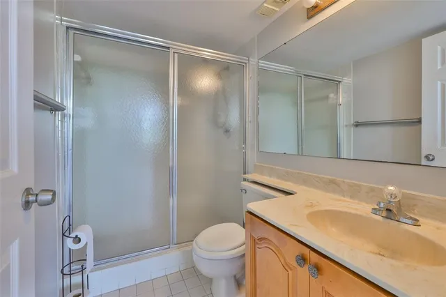 a bathroom with a sink a toilet a mirror and shower