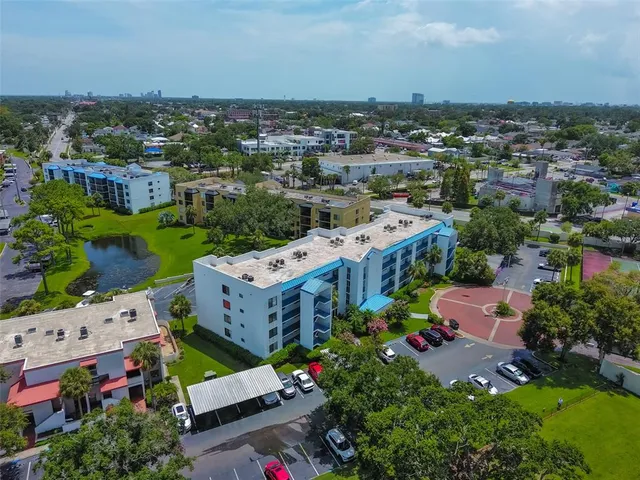 an aerial view of a house with a garden and lake view