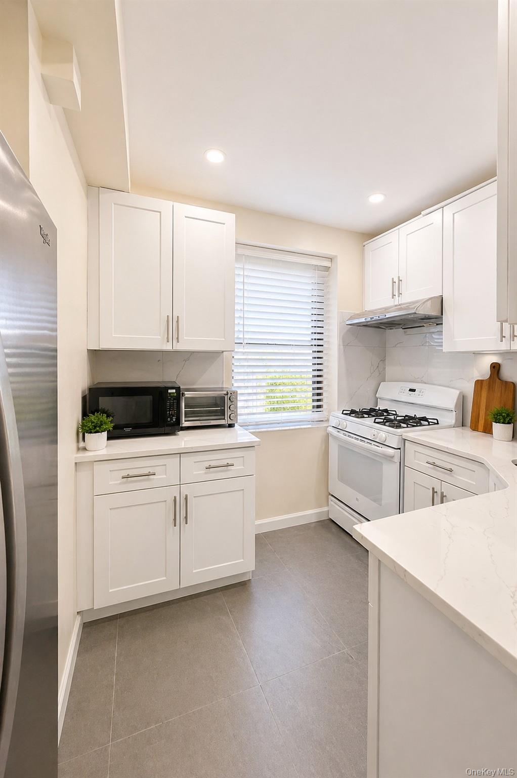 139-16 28th Road, Unit Z Queens, NY 11354 - Photo 5 of 14 a kitchen with granite countertop white cabinets and white appliances
