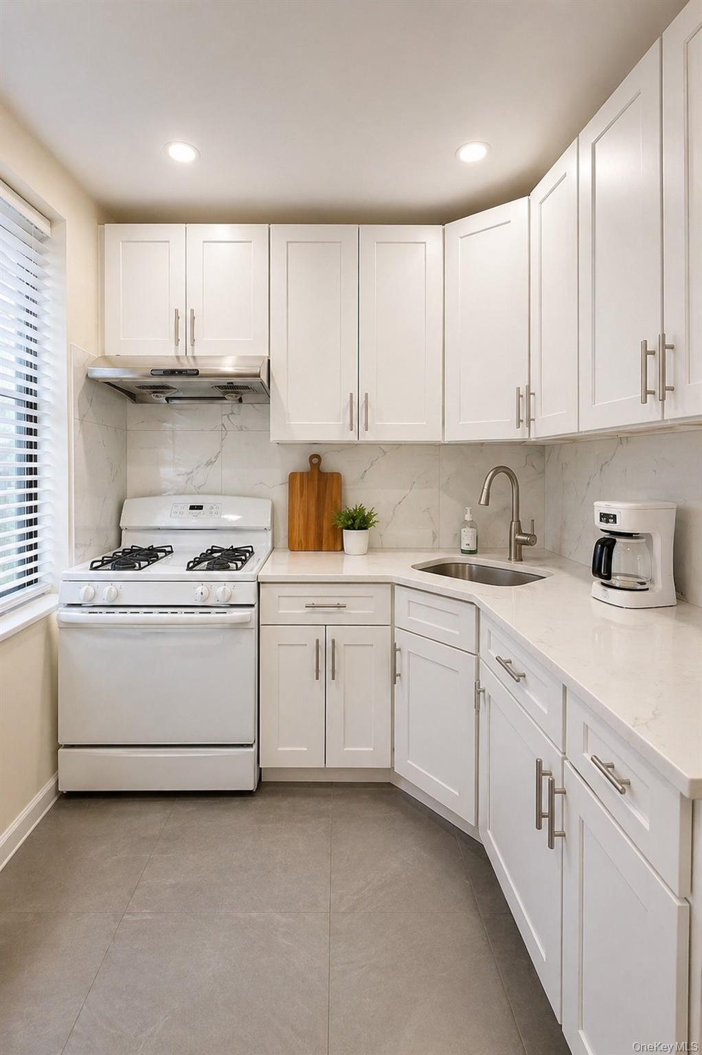 139-16 28th Road, Unit Z Queens, NY 11354 - Photo 6 of 14 a kitchen with granite countertop white cabinets and white appliances