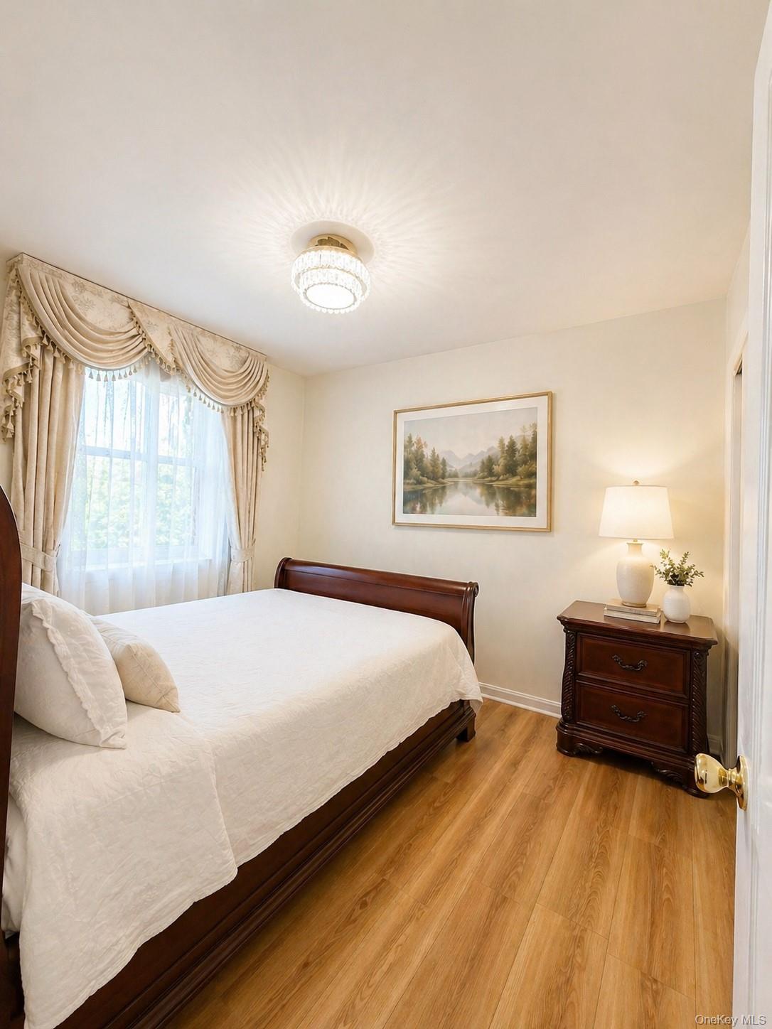 139-16 28th Road, Unit Z Queens, NY 11354 - Photo 8 of 14 a bedroom with a bed and a large window
