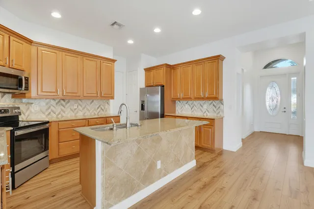 a kitchen with stainless steel appliances granite countertop a sink stove and microwave