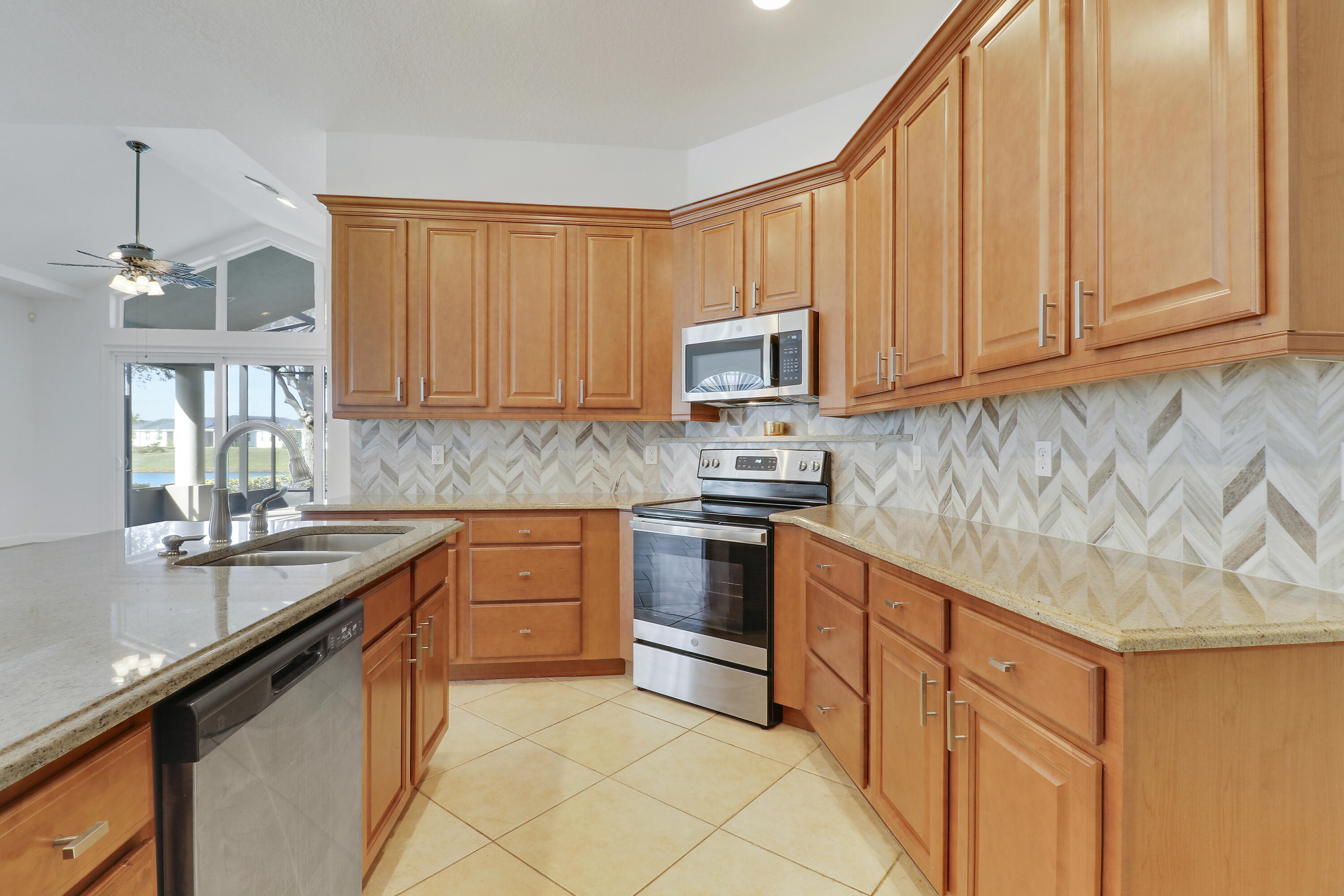 9212 Short Chip Circle Port St. Lucie, FL 34986 - Photo 13 of 71 a kitchen with stainless steel appliances granite countertop a sink stove and microwave