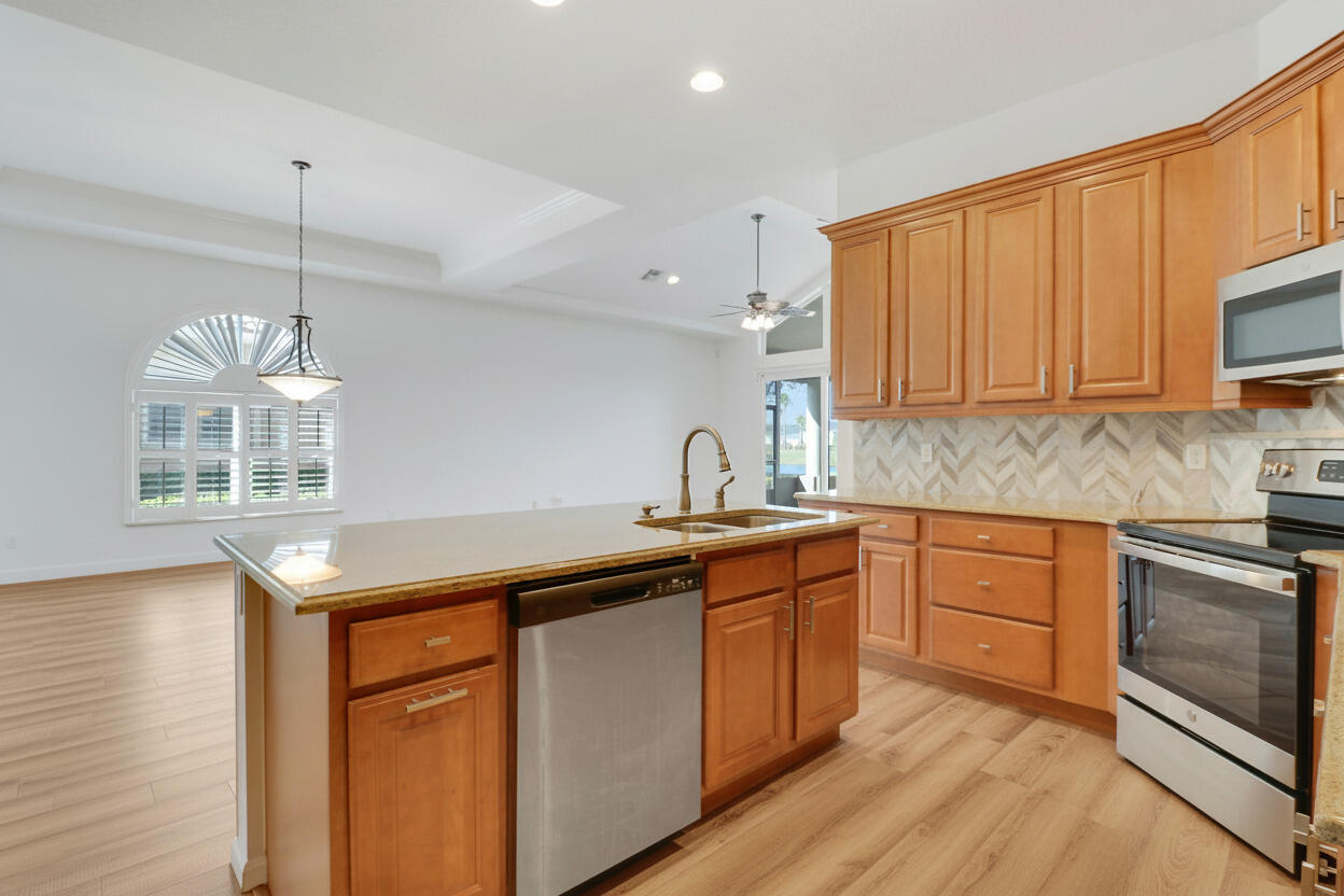 9212 Short Chip Circle Port St. Lucie, FL 34986 - Photo 15 of 71 a kitchen with stainless steel appliances granite countertop wooden cabinets granite counter tops and a hard wood floors