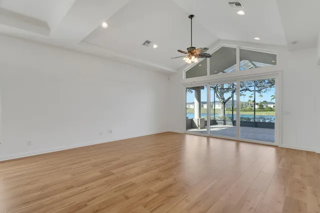 a view of an empty room with window and wooden floor
