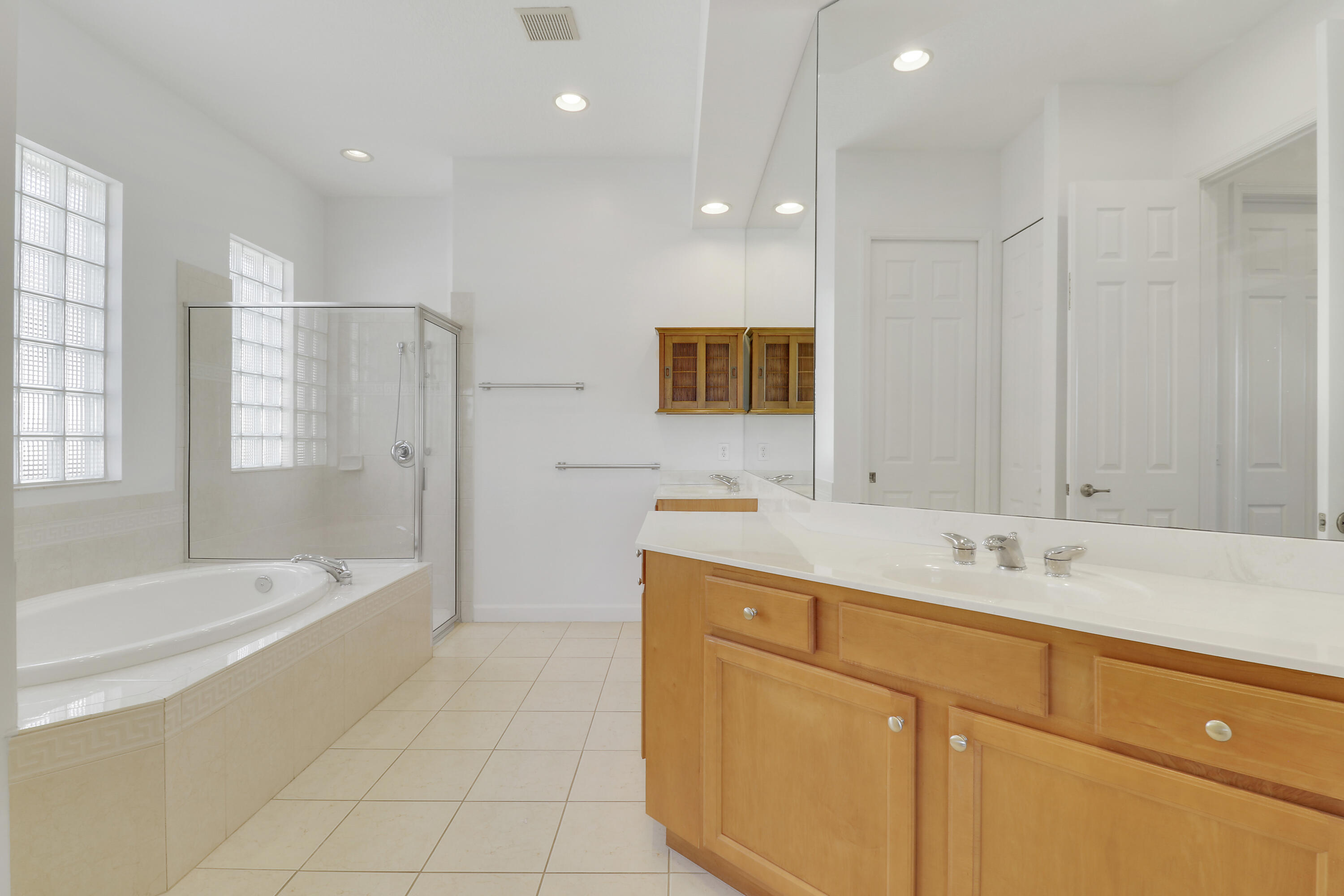 9212 Short Chip Circle Port St. Lucie, FL 34986 - Photo 30 of 71 a bathroom with a sink a mirror a bathtub and next to a window