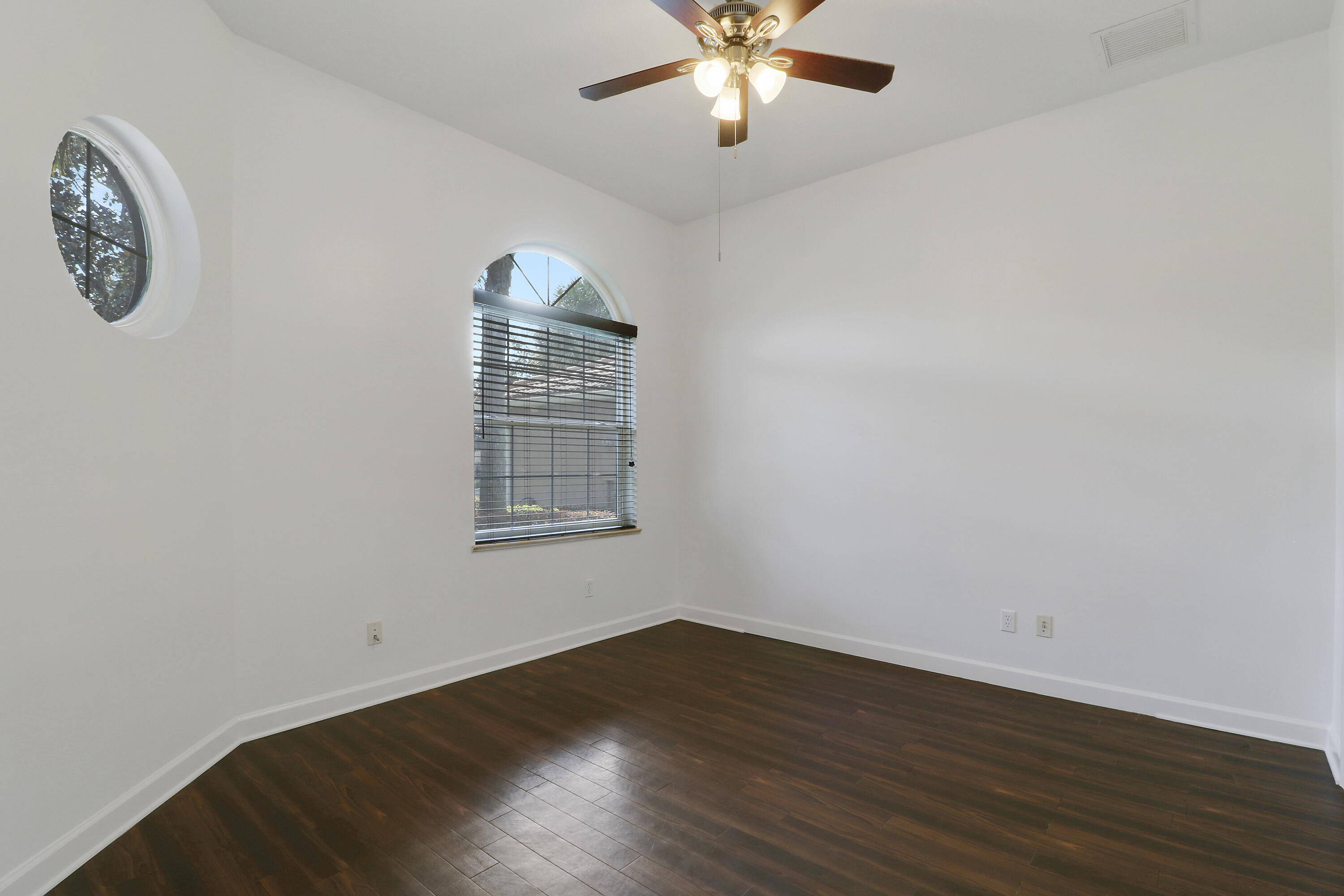 9212 Short Chip Circle Port St. Lucie, FL 34986 - Photo 36 of 71 an empty room with wooden floor and windows