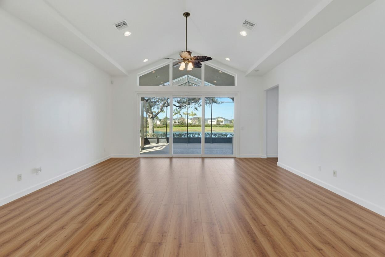 9212 Short Chip Circle Port St. Lucie, FL 34986 - Photo 7 of 71 an empty room with wooden floor chandelier fan and windows