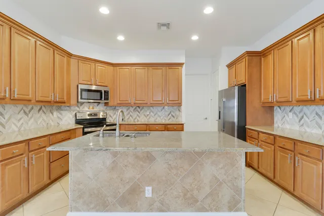 a large kitchen with stainless steel appliances granite countertop a granite counter tops and a wooden floors