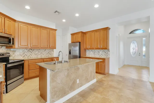 a kitchen with stainless steel appliances granite countertop a refrigerator a stove top oven a sink and dishwasher