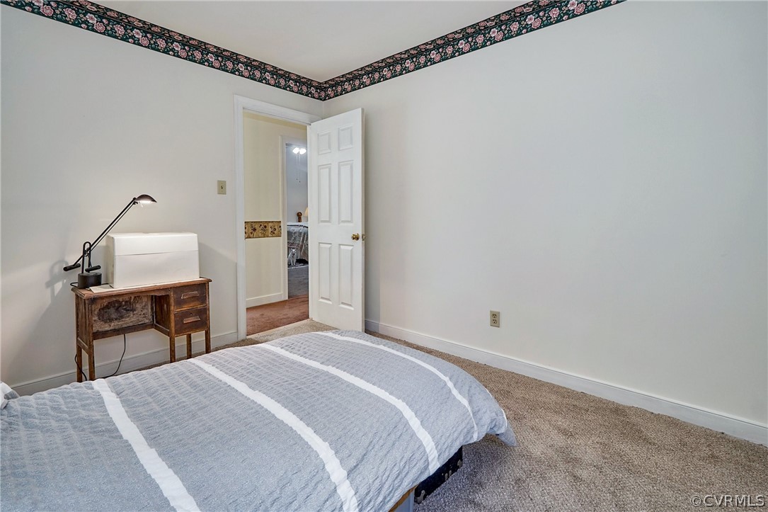 13816 Laurel Spring Road Chester, VA 23831 - Photo 23 of 31 a bedroom with a bed and wooden floor