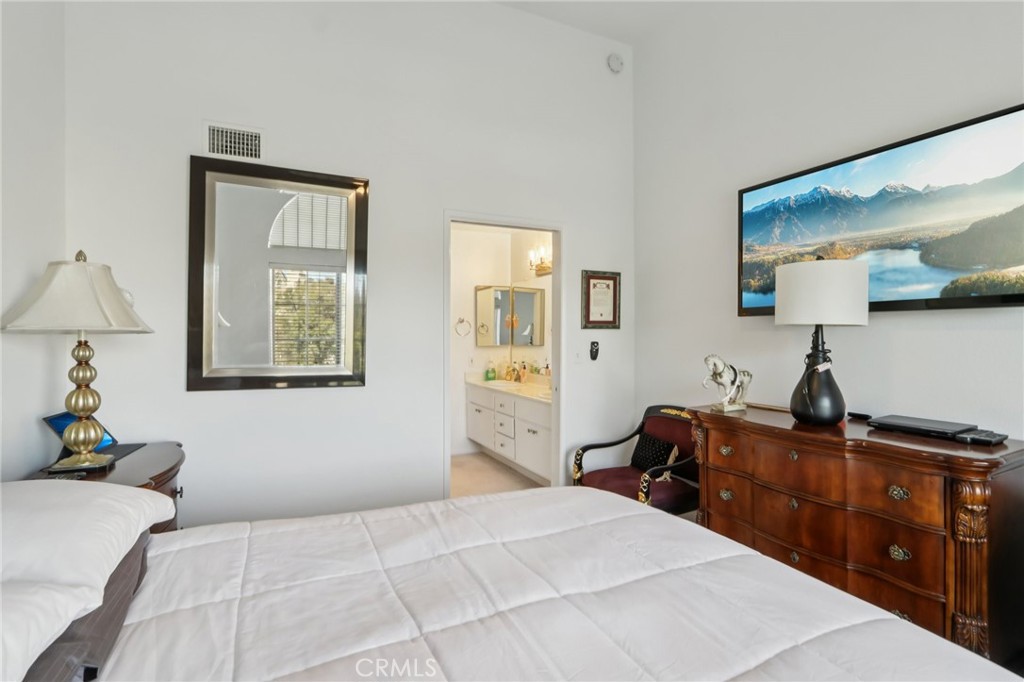 23605 Del Monte Dr., Unit 252 Valencia, CA 91355 - Photo 21 of 48 a bedroom with a bed and a flat tv screen on the dresser