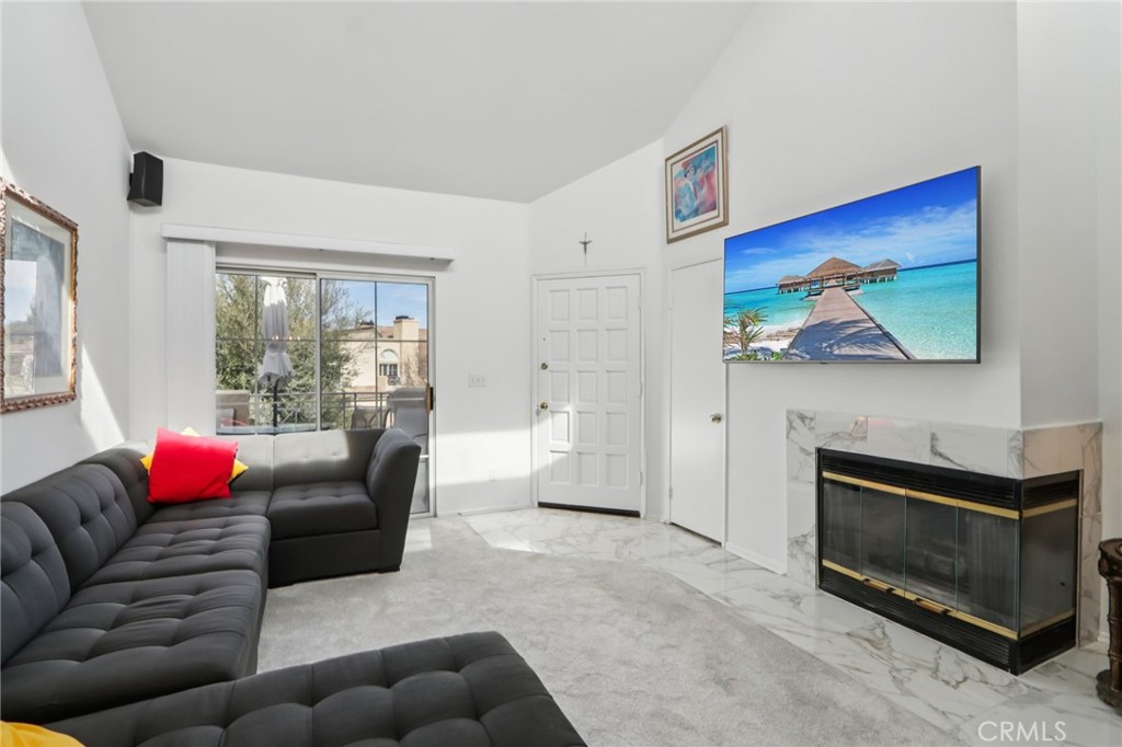 23605 Del Monte Dr., Unit 252 Valencia, CA 91355 - Photo 4 of 48 a living room with furniture a flat screen tv and a fireplace