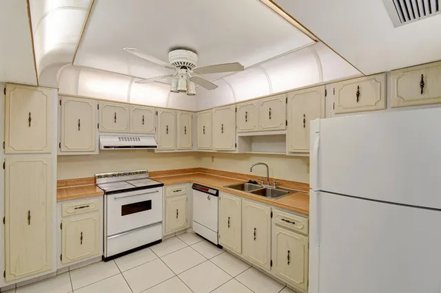 a kitchen with cabinets stainless steel appliances and a refrigerator