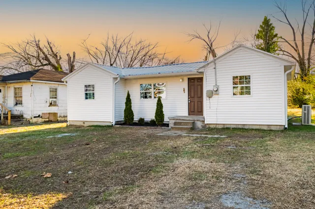a view of a white house with a yard