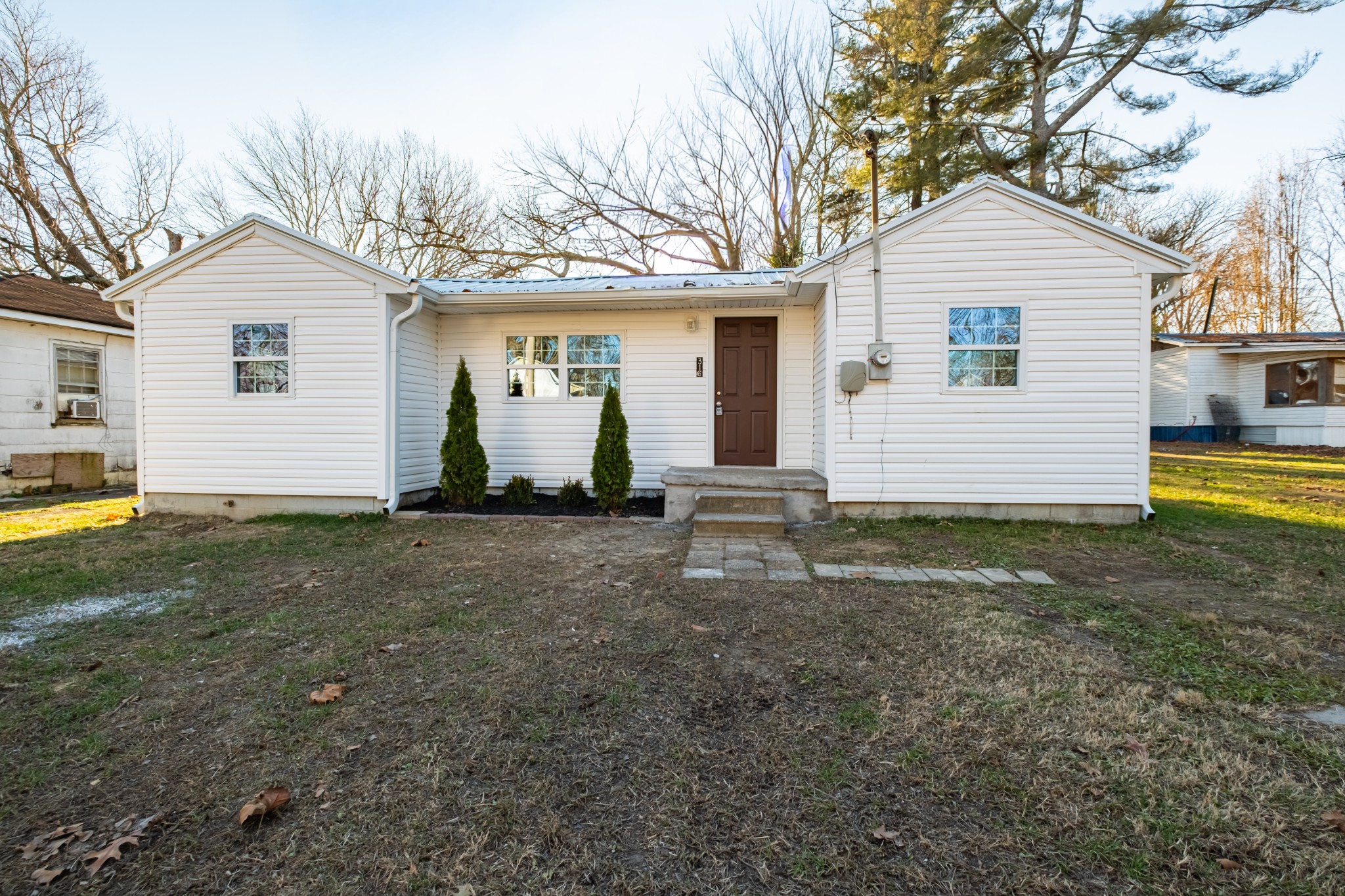 316 South Maple Street Tullahoma, TN 37388 - Photo 6 of 21 a view of a white house with a yard and table and chairs under an umbrella