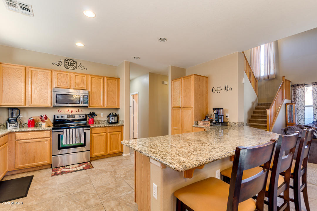 1163 East Ranch Court Gilbert, AZ 85296 - Photo 8 of 36 a kitchen with stainless steel appliances granite countertop a stove top oven a sink dishwasher and cabinets with wooden floor
