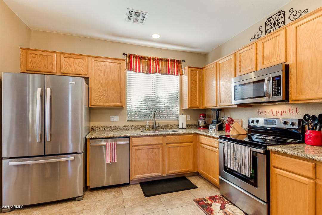 1163 East Ranch Court Gilbert, AZ 85296 - Photo 9 of 36 a kitchen with a sink a refrigerator and window
