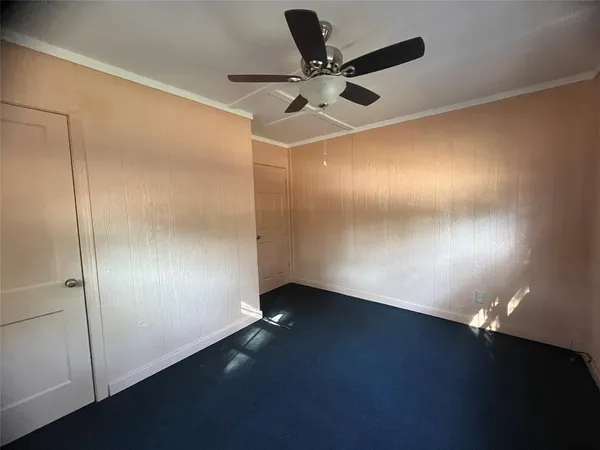 an empty room with a ceiling fan and wooden floor