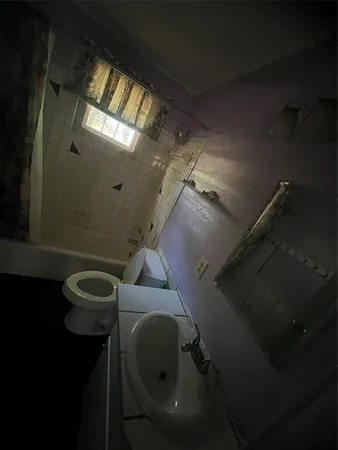 a bathroom with a toilet sink and mirror