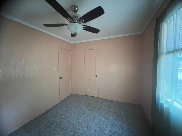 an empty room with a ceiling fan and fan