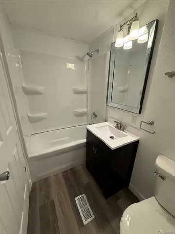 a bathroom with a sink mirror vanity and toilet