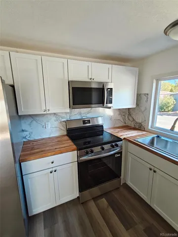 a kitchen with a sink stove and microwave