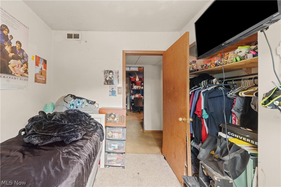 68-70 East Sunset Drive Rittman, OH 44270 - Photo 41 of 49 Carpeted room with a built-in closet featuring a clothes rod and shelving