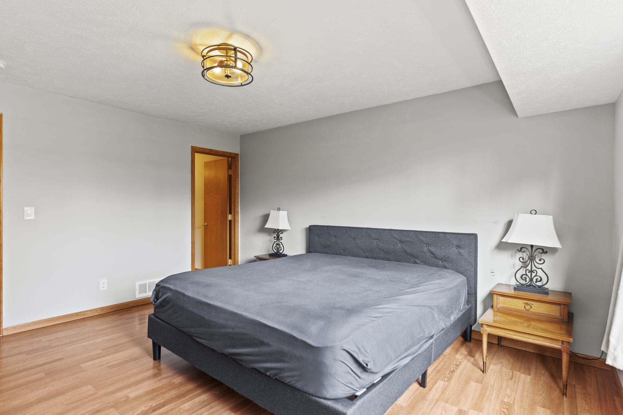 5694 Oak Village Drive Roscoe, IL 61073 - Photo 13 of 22 a bedroom with a bed and wooden floor