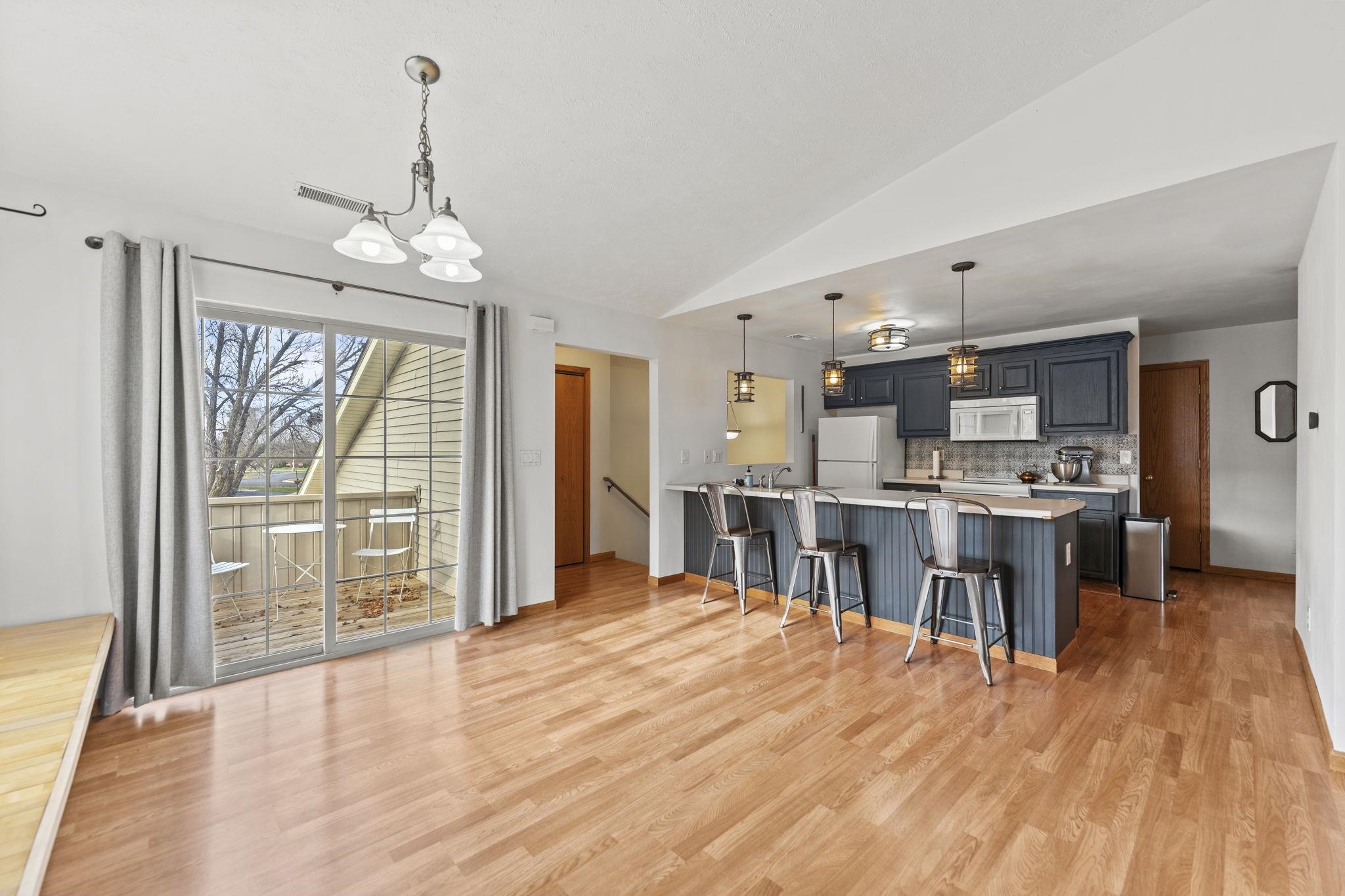 5694 Oak Village Drive Roscoe, IL 61073 - Photo 8 of 22 a open kitchen with stainless steel appliances granite countertop a refrigerator stove oven and white cabinets with wooden floor