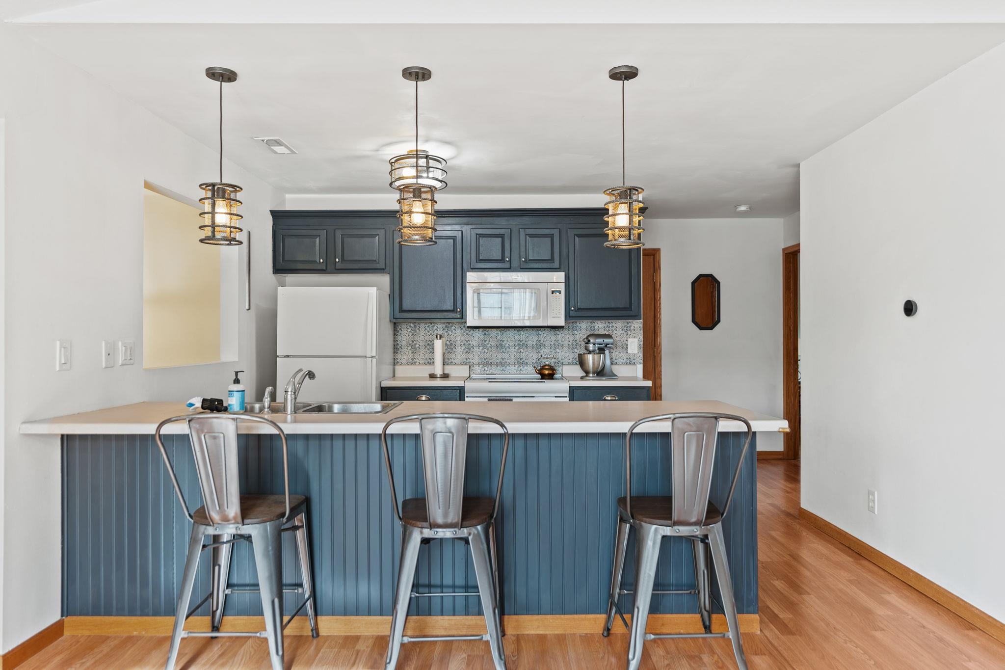 5694 Oak Village Drive Roscoe, IL 61073 - Photo 9 of 22 a kitchen with a dining table chairs and white cabinets