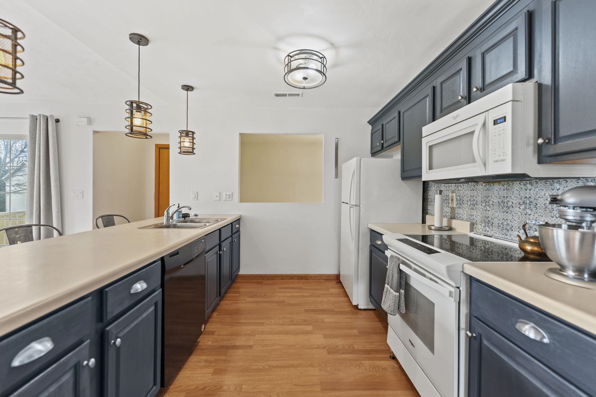 5694 Oak Village Drive Roscoe, IL 61073 - Photo 10 of 22 a kitchen with stainless steel appliances granite countertop a sink stove and refrigerator
