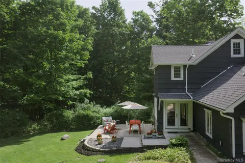 a view of a backyard with table and chairs potted plants and barbeque