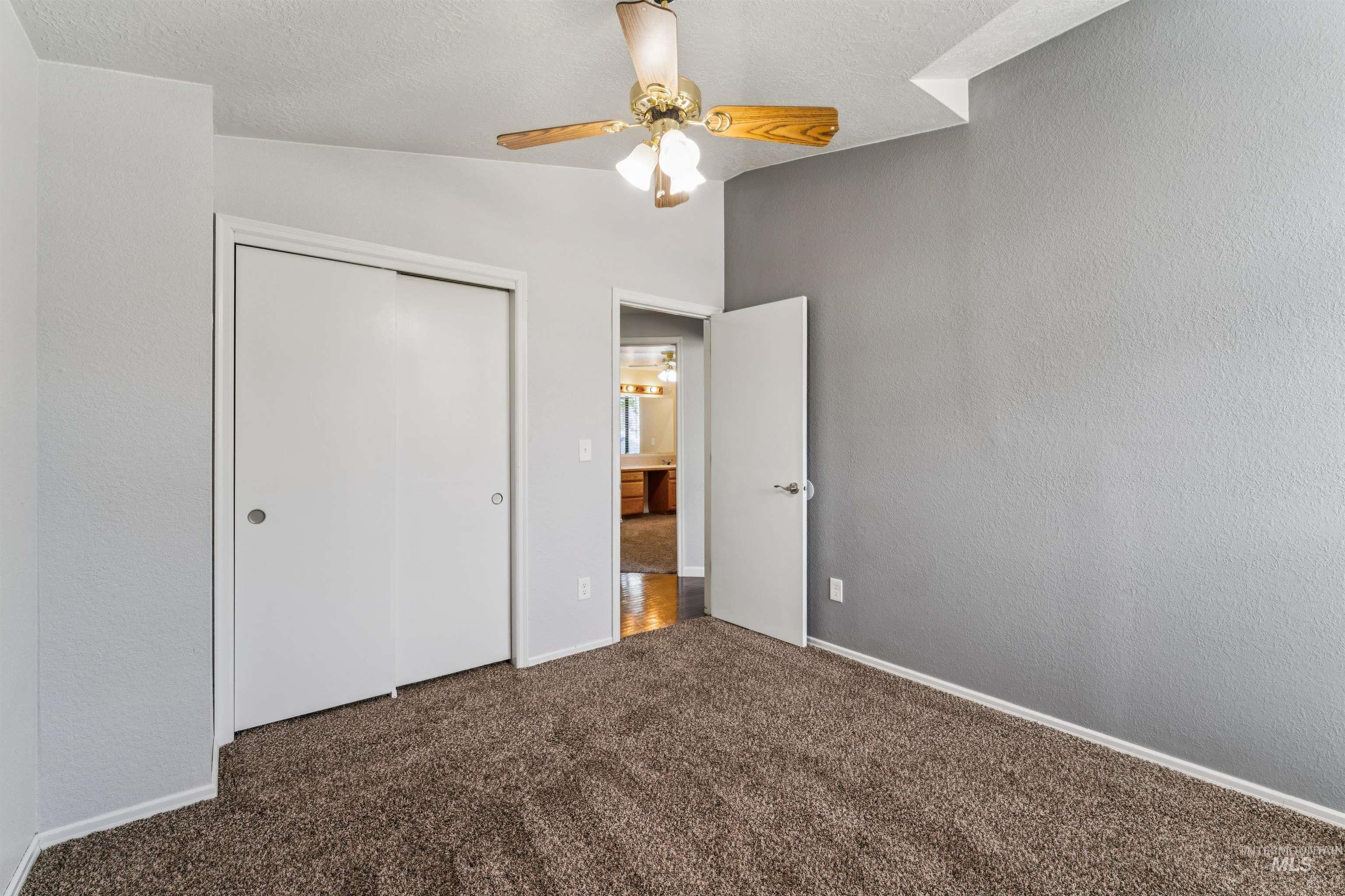 9831 West Ripley Street Boise, ID 83704 - Photo 28 of 47 Carpeted room with a distinctive window featuring an upper triangular pane and lower horizontal blinds