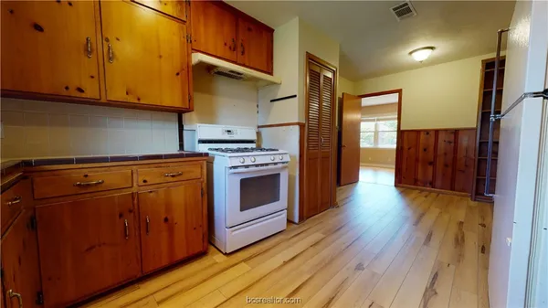 a kitchen with wooden floors and a stove top oven