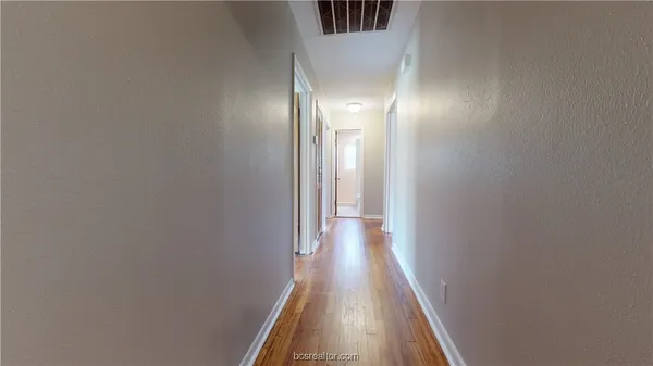 a view of a hallway with wooden floor