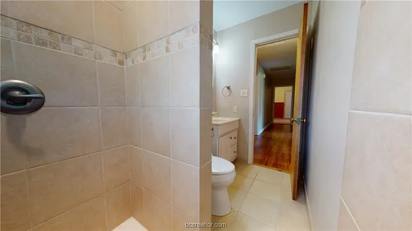 a bathroom with a granite countertop shower and a toilet